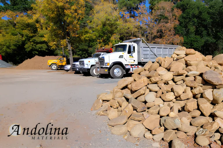 Landscape supply yard with rocks, trucks, and material piles.