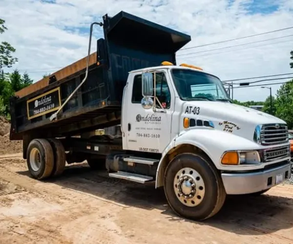 Dump truck delivering landscaping supply materials.