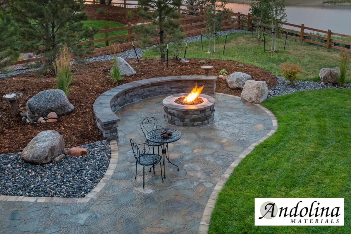 Landscaped patio with stone, mulch, rocks, and fire pit.