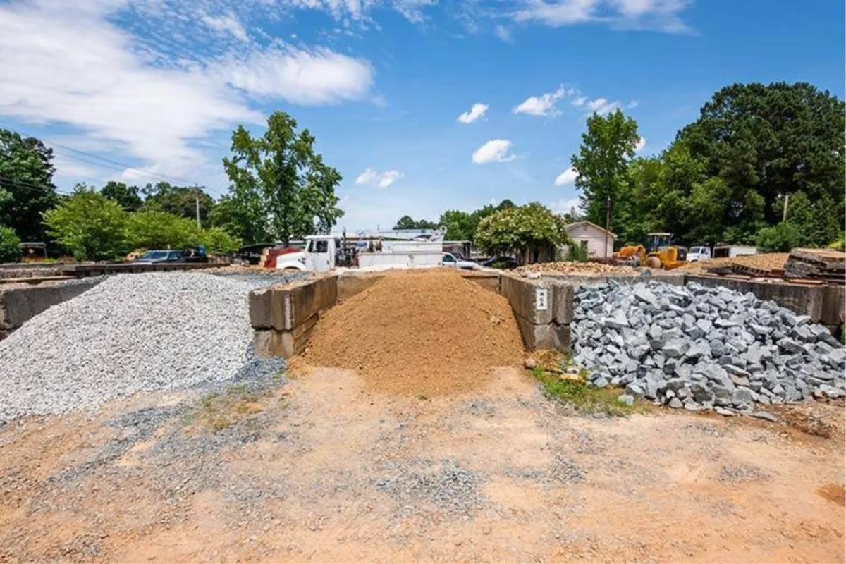 Landscape supply yard with piles of gravel and soil.